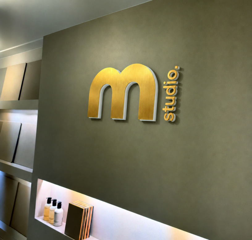 messing logo geborsteld met opaal acrylaat achterzijde gemonteerd op wand.